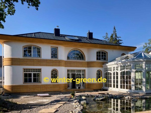 Orangerie Wintergarten mit Segmentbögen als Fitness- und Wellnessbereich, abgetrennt durch eine komplett verschiebbare Glaswand.