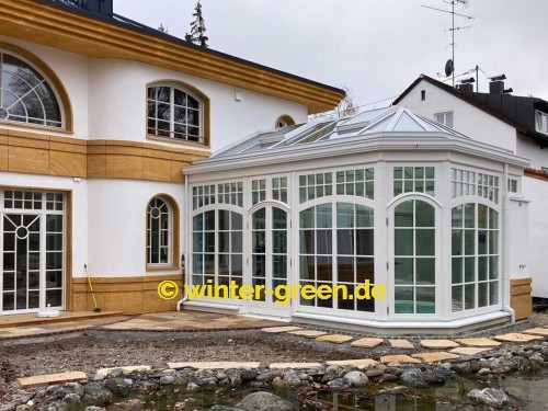 Orangerie Wintergarten mit Segmentbögen als Fitness- und Wellnessbereich, abgetrennt durch eine komplett verschiebbare Glaswand.