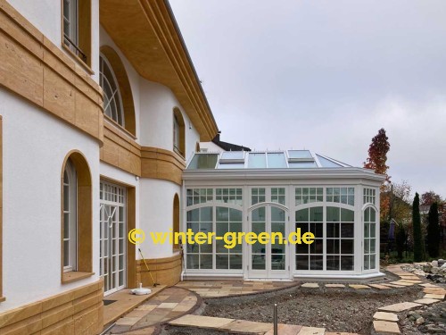 Orangerie Wintergarten mit Segmentbögen als Fitness- und Wellnessbereich, abgetrennt durch eine komplett verschiebbare Glaswand.