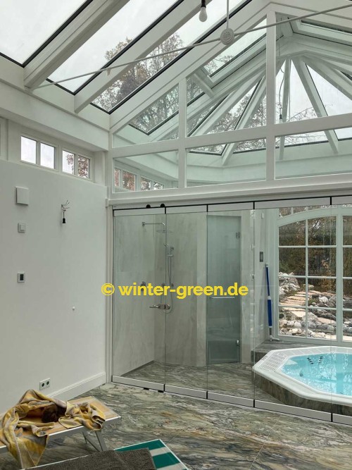 Orangerie Wintergarten mit Segmentbögen als Fitness- und Wellnessbereich, abgetrennt durch eine komplett verschiebbare Glaswand.