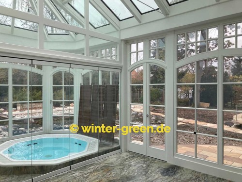 Orangerie Wintergarten mit Segmentbögen als Fitness- und Wellnessbereich, abgetrennt durch eine komplett verschiebbare Glaswand.